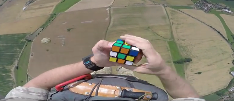 Soldier Attempts to Solve a Rubik’s Cube After Jumping From a Plane